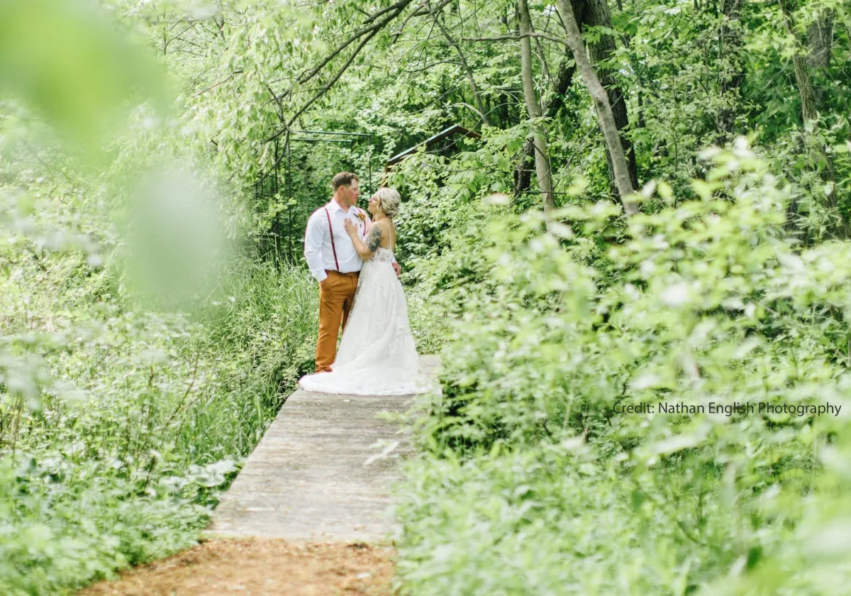 Bride and groom standing at end of ceremony walkway at Briar Barns historic wedding venue Sparta Michigan